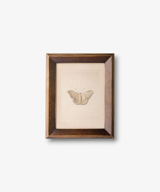 Framed artwork of a butterfly on a beige background