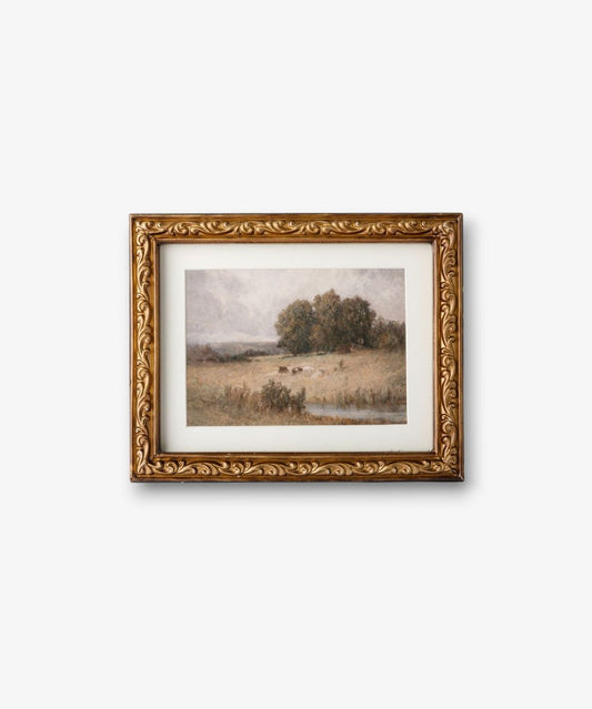 Framed landscape painting with gold detailing on a white background