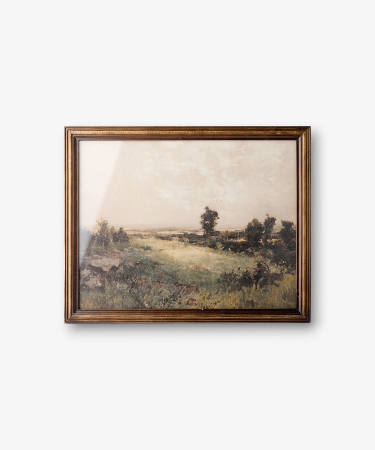 Framed landscape painting on a white wall