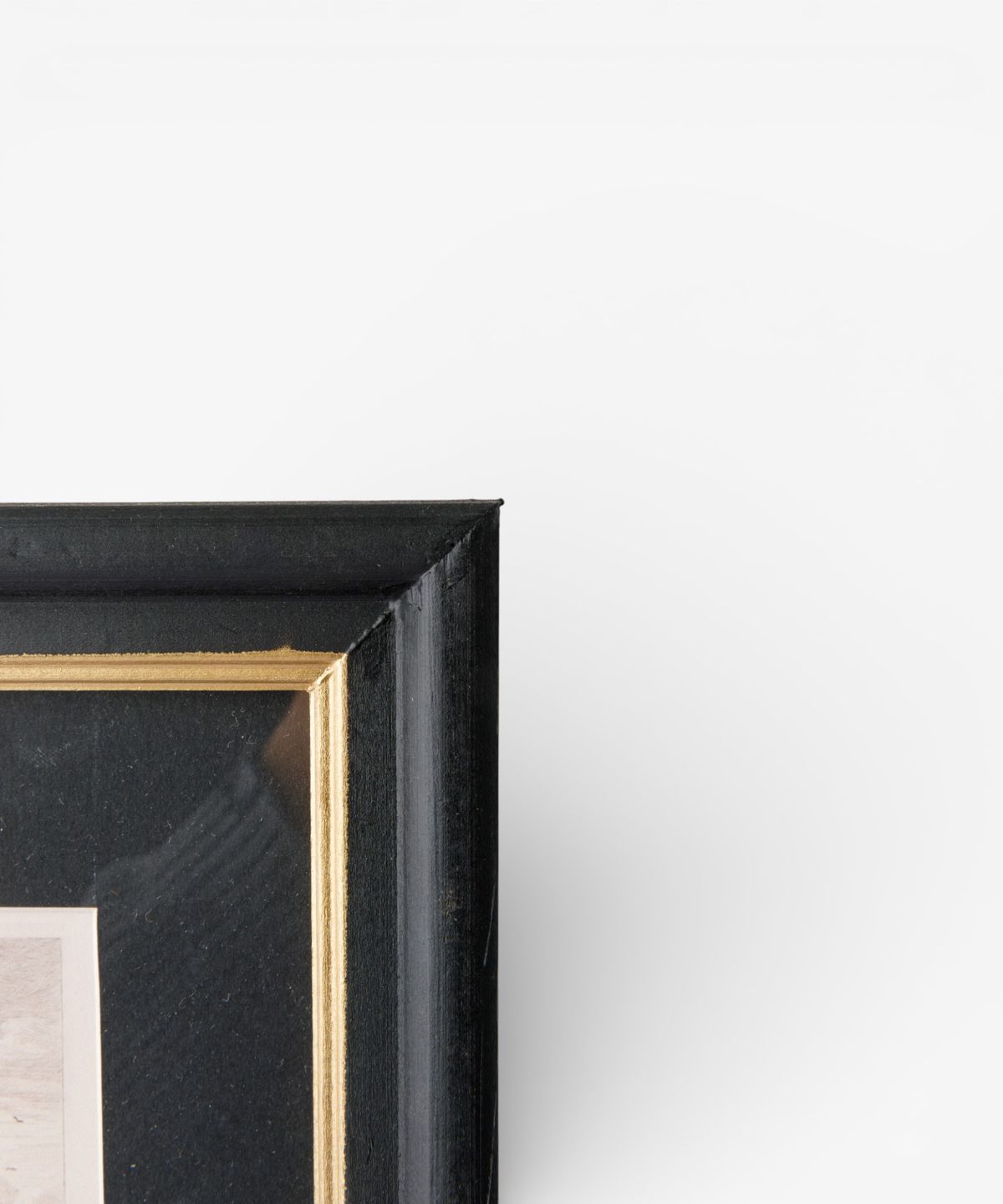 Black picture frame with gold trim on a white background