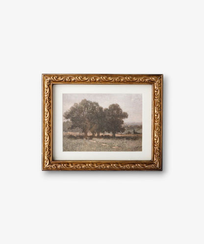 Framed artwork of a landscape with trees on a white wall