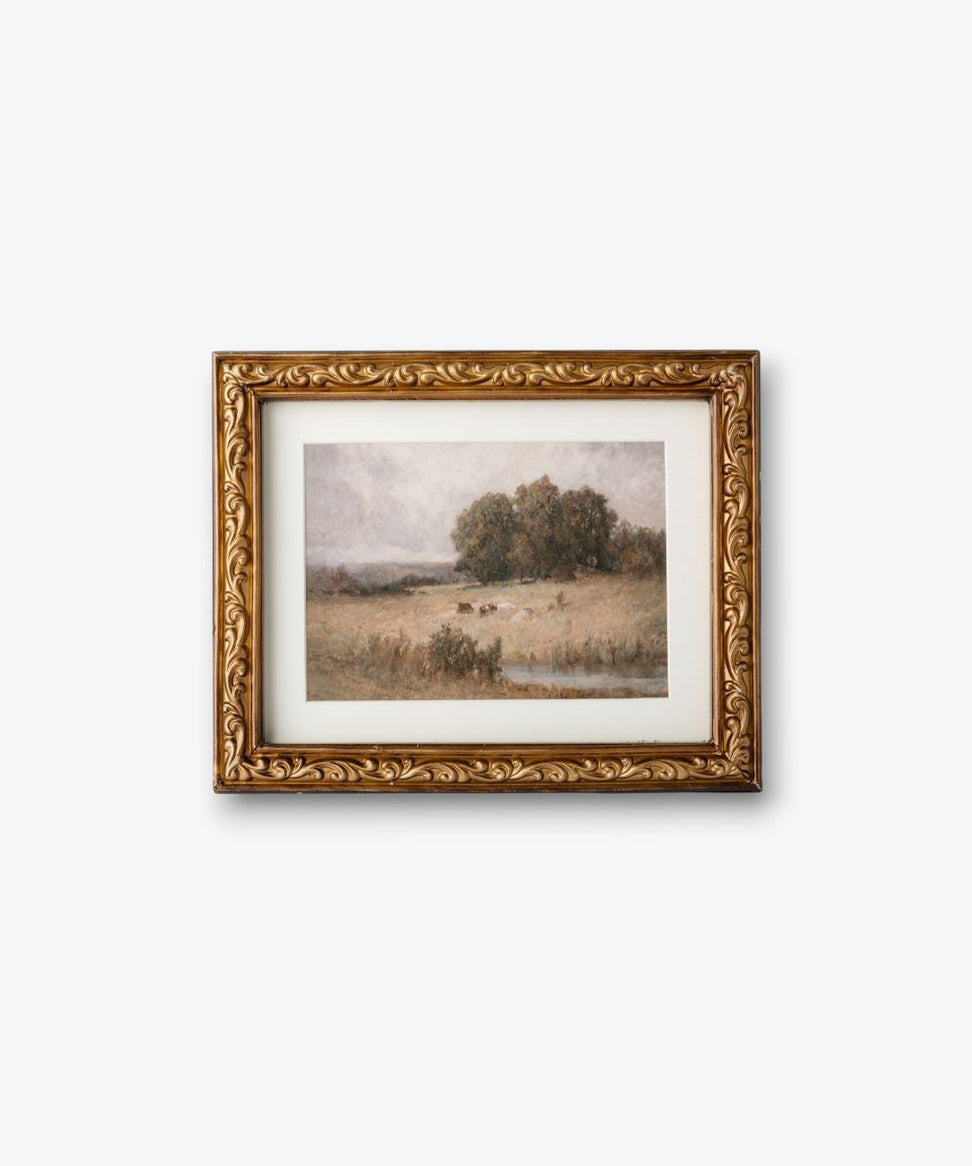 Framed landscape painting with gold detailing on a white background