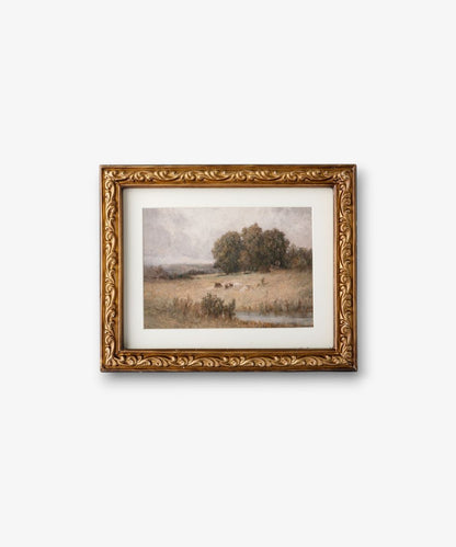 Framed landscape painting with gold detailing on a white background
