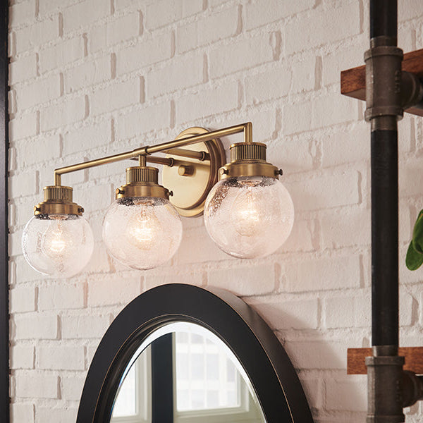 Poppy wall brackets by Hinkley in Heritage Brass in a styled bathroom